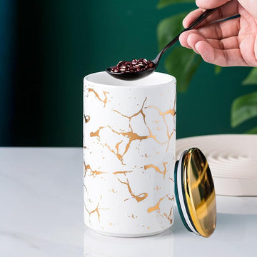 Elegant ceramic food storage jar with golden marble design, black and white, used for organizing kitchen and food